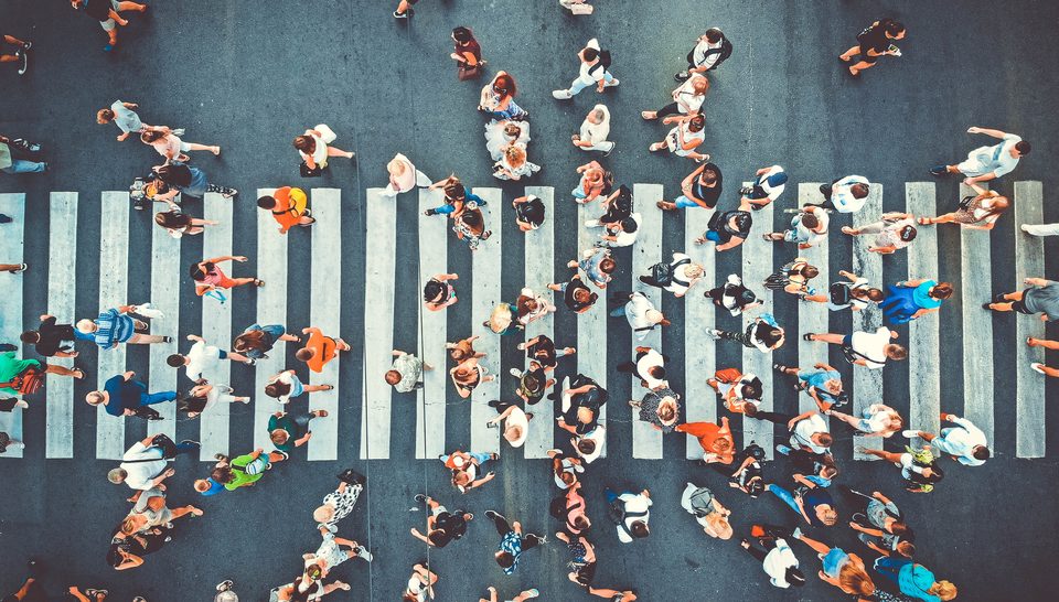 Crosswalk seen from above with dozens of people crossing